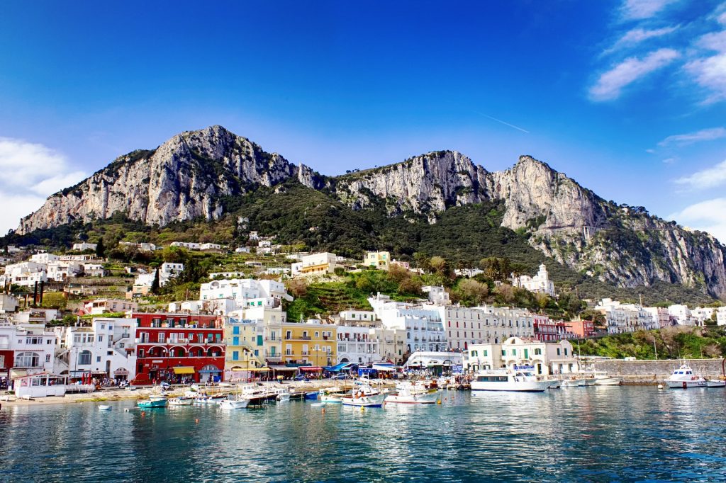 A colorful and picturesque street in the center of Capri, lined with shops, restaurants, and flowers in bloom.